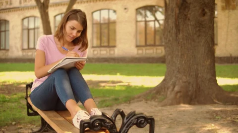Free Video Stock Student Girl Writing In The Gardens Of A College Live Wallpaper - Free Live Wallpaper