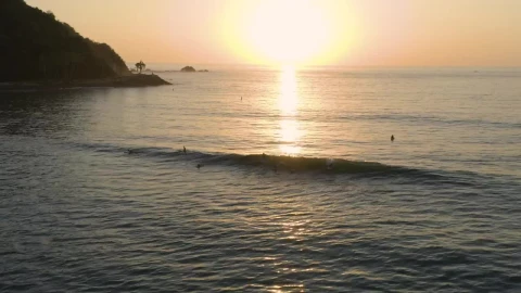 Free Video Stock surfing waves near a shoreline at sunset Live Wallpaper - Free Live Wallpaper