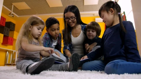 Free Video Stock teacher with children reading a book on the carpet Live Wallpaper - Free Live Wallpaper