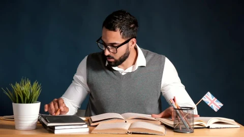 Free Video Stock teacher works at desk in classroom with chalkboard background Live Wallpaper - Free Live Wallpaper