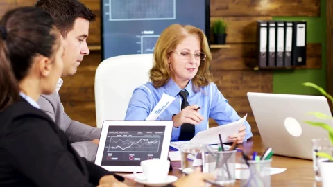 Free Video Stock team leader hands out growth charts at meeting Live Wallpaper - Free Live Wallpaper