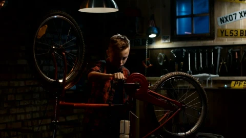 Free Video Stock teen boy repairing his bicycle in the garage Live Wallpaper - Free Live Wallpaper