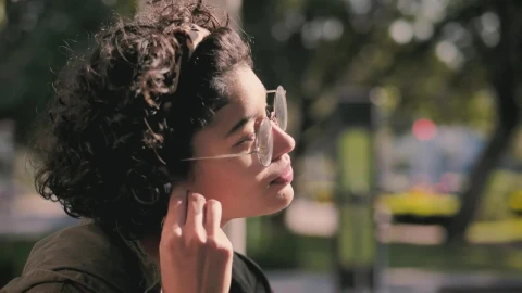 Free Video Stock teenager putting on headphones in the park Live Wallpaper - Free Live Wallpaper