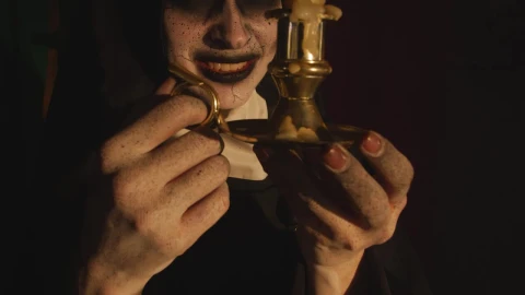 Free Video Stock terrifying nun looking at a candle in her hands Live Wallpaper - Free Live Wallpaper