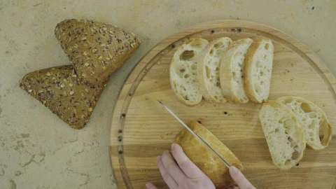 Free Video Stock top view of hands cutting fresh bread on wood board Live Wallpaper - Free Live Wallpaper