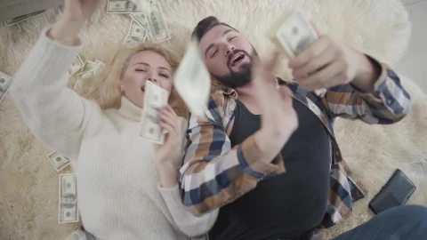 Free Video Stock top view of rich couple on rug laying in money Live Wallpaper - Free Live Wallpaper