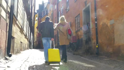 Free Video Stock tourists walking through a city with their luggage Live Wallpaper - Free Live Wallpaper
