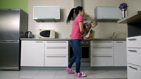 Free Stock Video Young Woman Cooking In A Kitchen Carrying Her Baby Live Wallpaper - Free Live Wallpaper