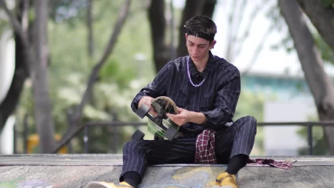 Free Stock Video Young Skateboarder Sitting Placing His Skateboard Aside Live Wallpaper - Free Live Wallpaper