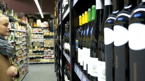 Stock Footage Woman Choosing A Bottle Of Wine Live Wallpaper - Free Live Wallpaper