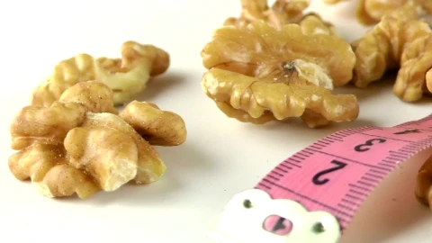 Stock Footage Walnuts And Measure Tape On White Table Live Wallpaper - Free Live Wallpaper