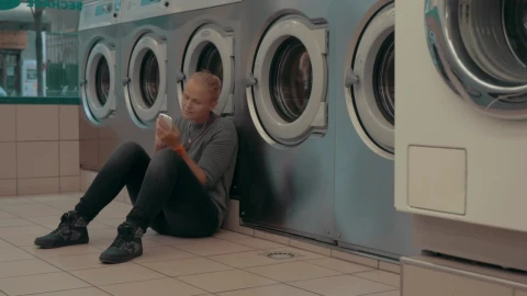 Stock Footage Woman Waiting For Her Laundry To Finish Live Wallpaper Free - Free Live Wallpaper