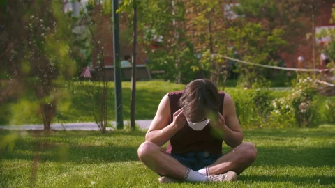Stock Footage Young Man Sitting In The Park Puts On A Face Live Wallpaper Free - Free Live Wallpaper