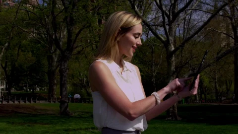 Stock Footage Woman Scrolling On A Tablet In Central Park Live Wallpaper Free - Free Live Wallpaper
