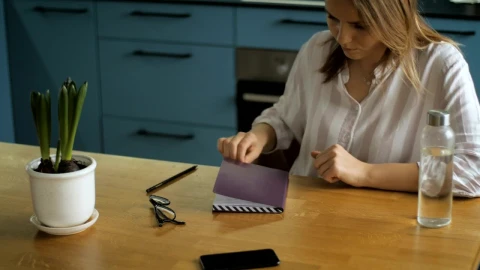 Stock Footage Young Woman Writing On A Notebook In The Kitchen Live Wallpaper Free - Free Live Wallpaper