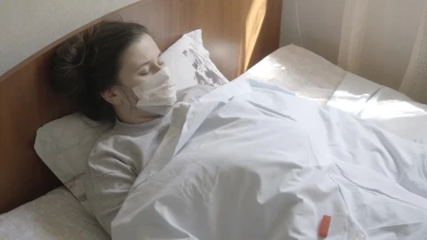 Stock Footage Woman In Face Mask Checks Thermometer While In Bed Live Wallpaper Free - Free Live Wallpaper