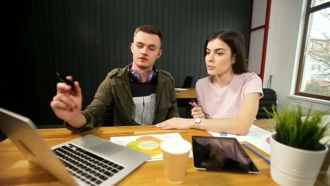 Stock Footage Young Man Explains Idea To Partner And Points To Laptop Live Wallpaper Free - Free Live Wallpaper