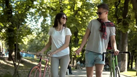 Stock Footage Young Couple Walk Bikes On Tree Lined Street Live Wallpaper Free - Free Live Wallpaper