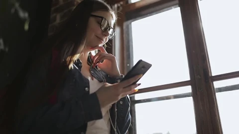 Stock Footage Young Girl Smiles At Facebook Post On Mobile Phone Live Wallpaper Free - Free Live Wallpaper