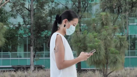 Stock Footage Woman With Face Mask Walking While Texting Live Wallpaper Free - Free Live Wallpaper