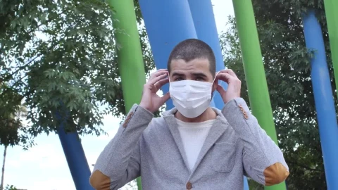Stock Footage Young Man In A Park Putting On A Face Mask Live Wallpaper Free - Free Live Wallpaper