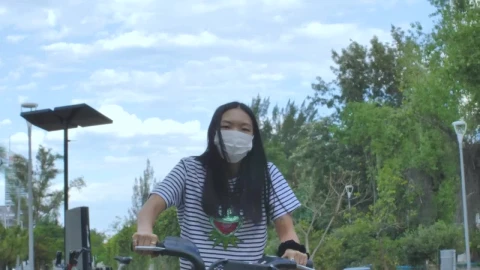 Stock Footage Woman With Mask On Bicycle In A Park Live Wallpaper Free - Free Live Wallpaper