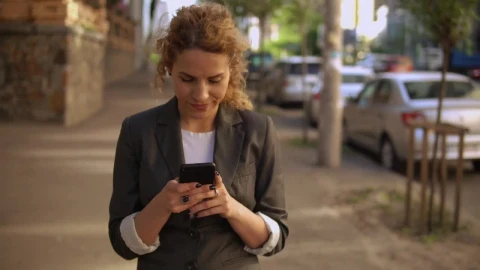 Stock Footage Woman Walking Down The Street Watching Her Cell Phone Live Wallpaper Free - Free Live Wallpaper