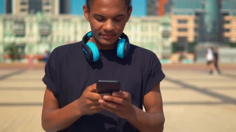 Stock Footage Young Man On The Street Typing On His Cell Phone Live Wallpaper Free - Free Live Wallpaper