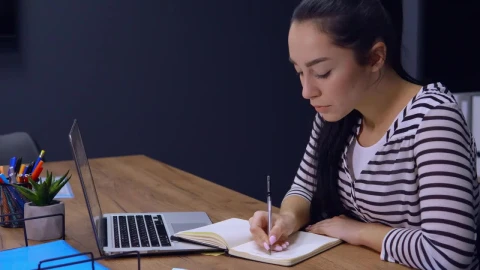 Stock Footage Young Woman Writes A List On Her Work Schedule Live Wallpaper Free - Free Live Wallpaper