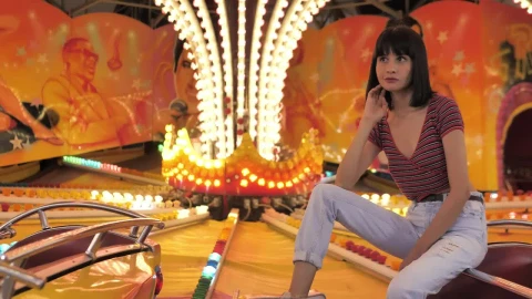 Stock Footage Woman Sitting On A Bright Fair Game Live Wallpaper Free - Free Live Wallpaper